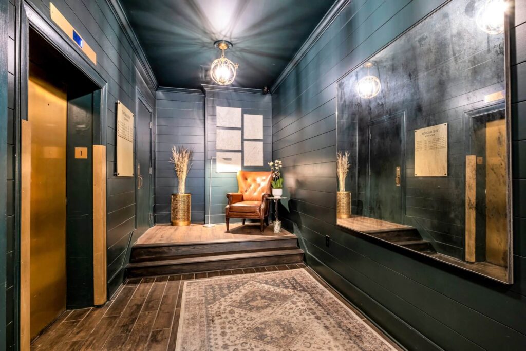 Elegant hallway with dark walls, vintage furniture, and brass accents.
